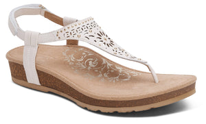 White sandal with t-strap and ankle strap, low wedge heel, perforated design on the upper.