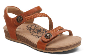 A pair of brown, flat sandals with braided straps and button accents.