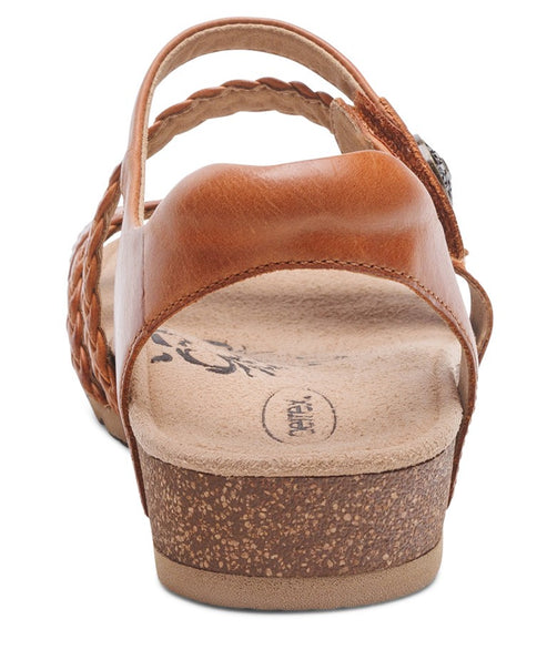 Angled rear view of tan sandals with braided straps and cork soles.