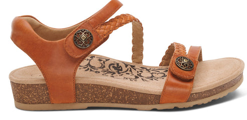 Orange sandal with braided straps and decorative buttons.