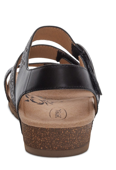 Black sandal with cork sole, featuring straps with floral designs.