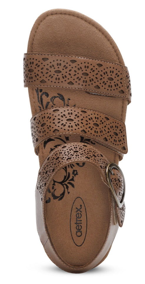 Sandal with three perforated brown straps and a buckle closure.