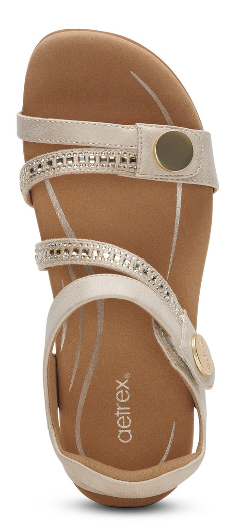 Sandal with multiple straps, rhinestone embellishments and circular hardware.