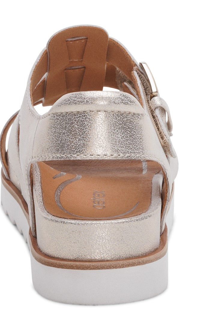 Back view of metallic gold sandal with buckled ankle strap and white platform sole.