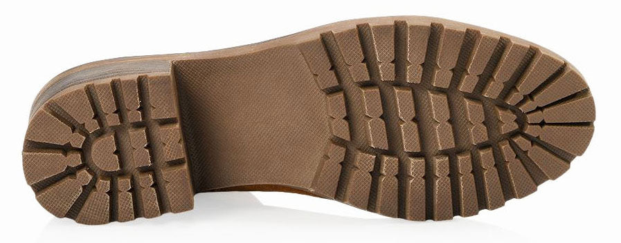 The sole of a lug-soled boot is tan with a block heel and deeply grooved treads.