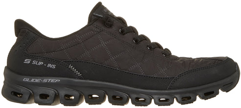 A black Skechers Slip-Ins Glide-Step athletic shoe, viewed from the side, with a quilted fabric upper, a thick lugged sole featuring visible cutouts, and laces on the upper.