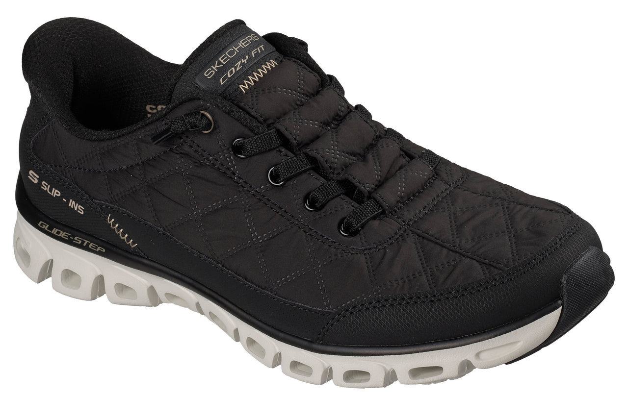 Black quilted athletic shoe with white sole, labeled 'SKECHERS COZY FIT' and 'GLIDE-STEP'.