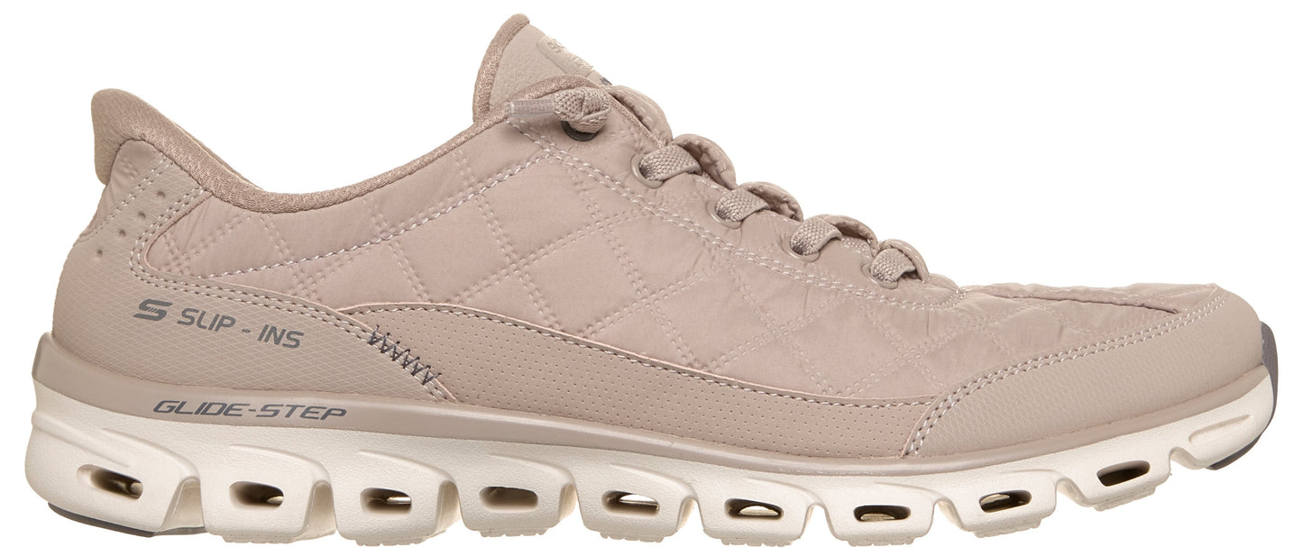 A light beige, low-top sneaker featuring a quilted fabric upper, a padded collar with a pull tab at the heel, and a thick, white, segmented midsole with cutouts. Visible text on the side reads "S SLIP-INS" and "GLIDE-STEP".