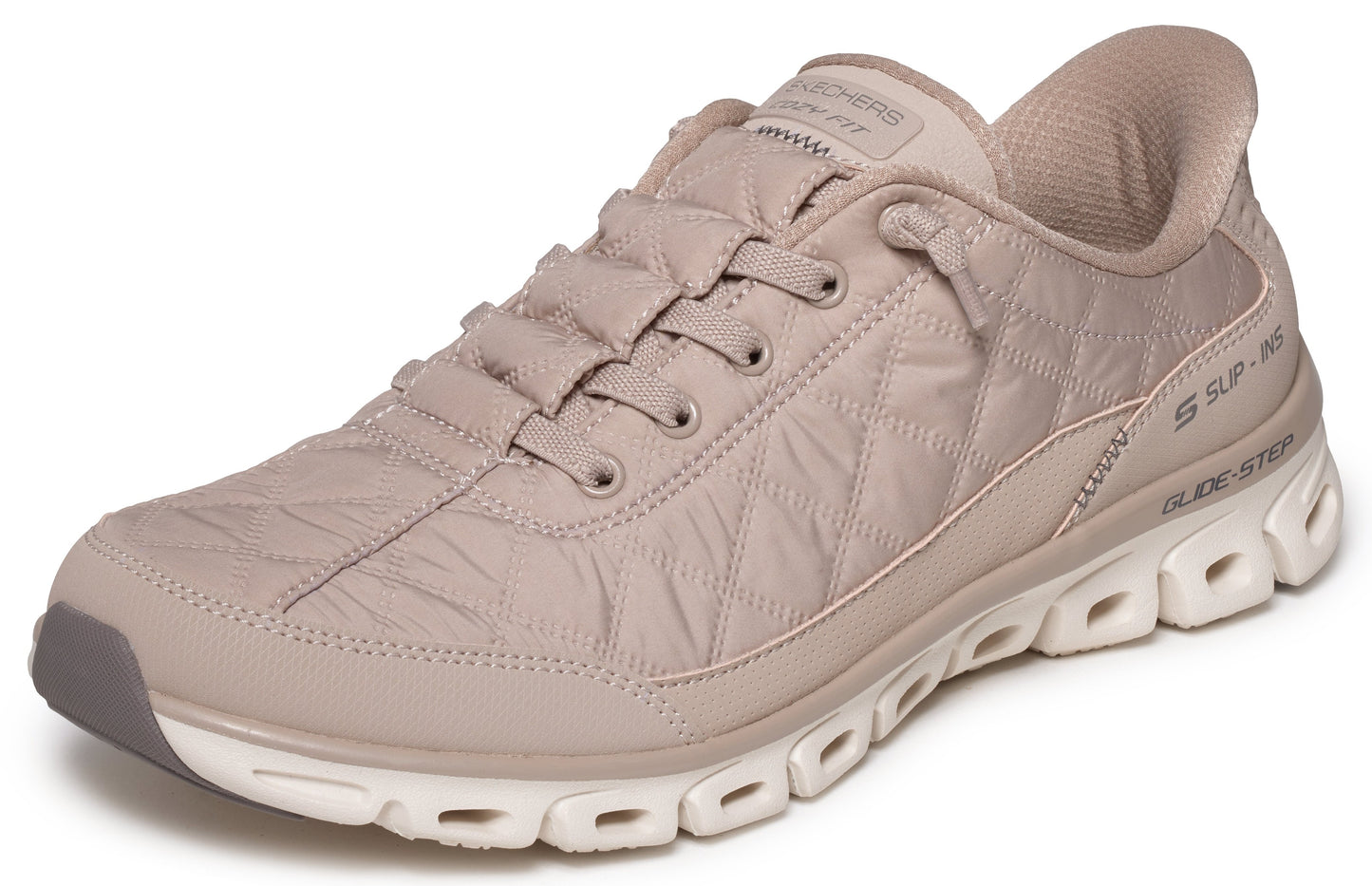 A beige, quilted slip-on athletic shoe with matching laces and a thick white, geometric-patterned sole.