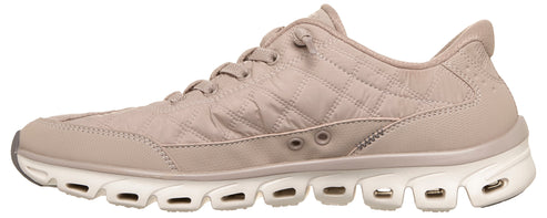A light beige, quilted, lace-up athletic shoe with a thick, white, multi-chambered cushioned sole featuring circular cutouts along the sides.