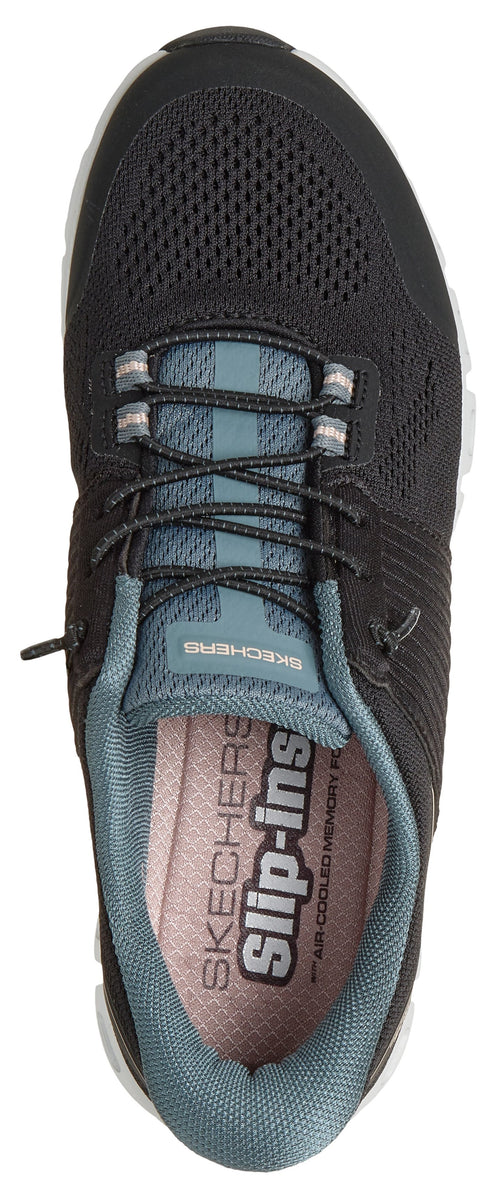 A top-down view of a dark grey Skechers Slip-ins athletic sneaker with a mesh upper, elastic laces, and a blueish-grey tongue and interior lining, featuring the words 'Skechers Slip-ins' printed clearly on the insole.
