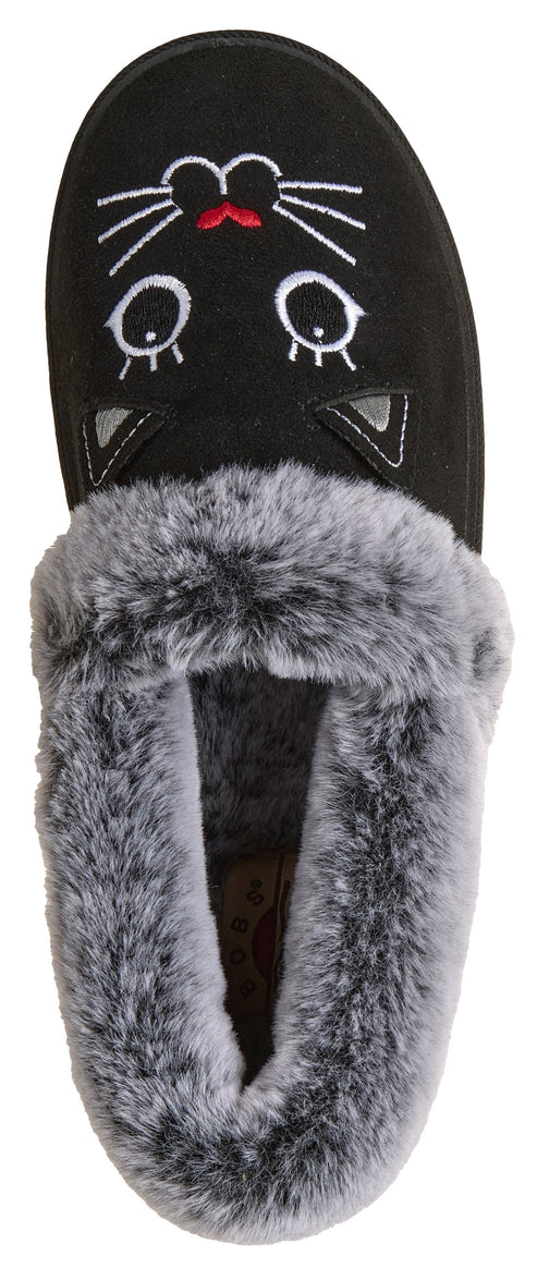 A black plush slipper with an embroidered white cat face, including whiskers, eyes, and small grey triangular ears, lined with grey faux fur.