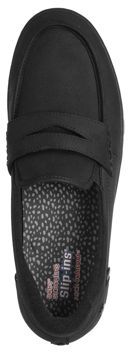 A black slip-on loafer shoe viewed from above, featuring a moc-toe design, a decorative strap across the vamp, and a patterned inner sole with the text 'Skechers slip-ins' and 'Arch Fit' visible.