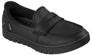 A black loafer shoe with a textured thick sole, a stitched strap across the top, and a visible brand tag on the side.