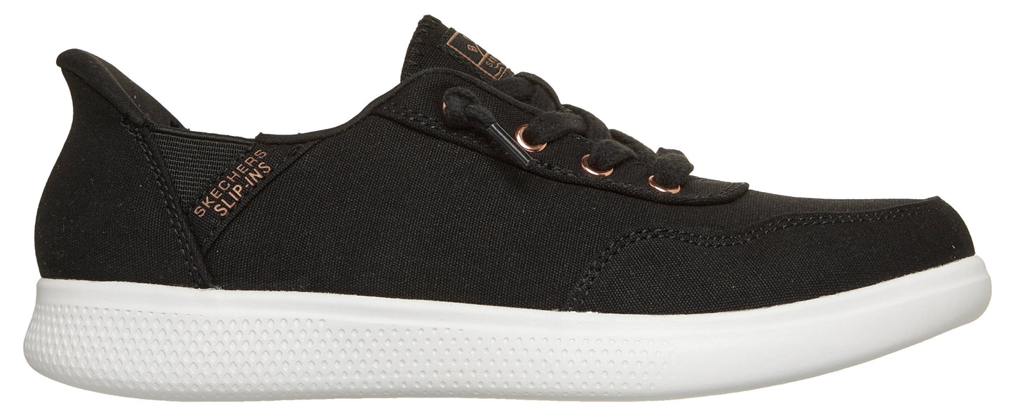 A black slip-on sneaker with white soles and rose gold eyelets.