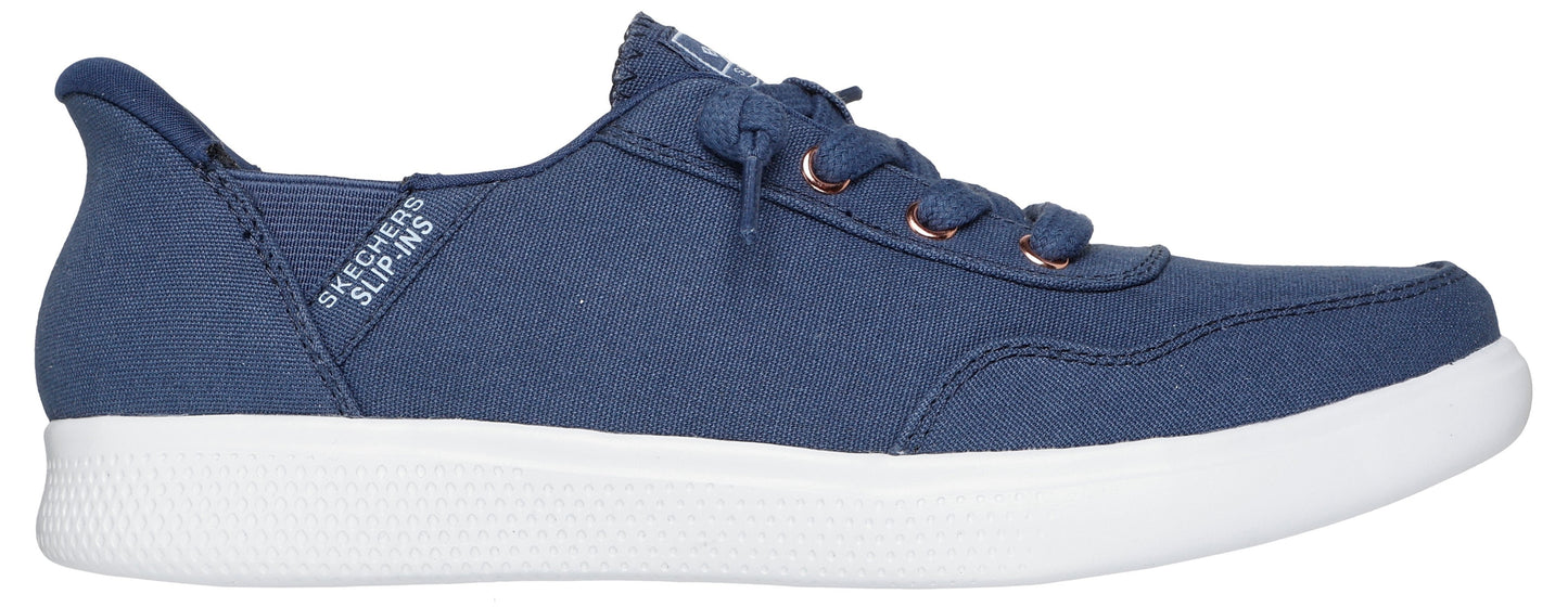 A navy blue sneaker with white soles and copper-colored eyelets. The shoe has a slip-in design.