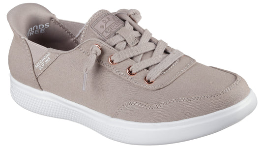 A tan-colored canvas sneaker with laces and a white sole.