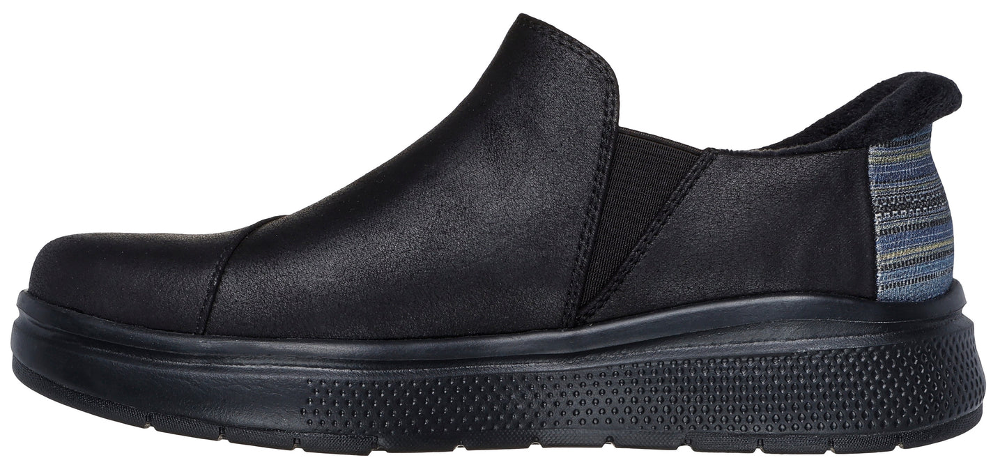 A black slip-on shoe with a thick sole and a striped fabric panel on the heel.