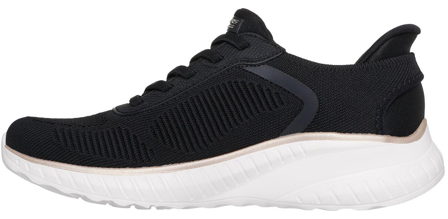 A black athletic sneaker with a white cushioned sole and a thin copper-colored accent line along the midsole.