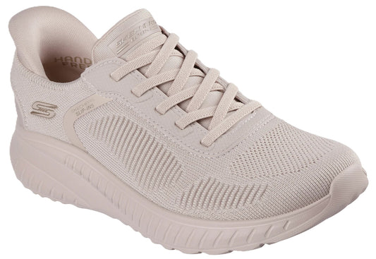 A light beige, lace-up athletic sneaker with a textured mesh upper and a chunky matching rubber sole, featuring a visible S logo on the side and the words Hand Free printed inside the heel collar.