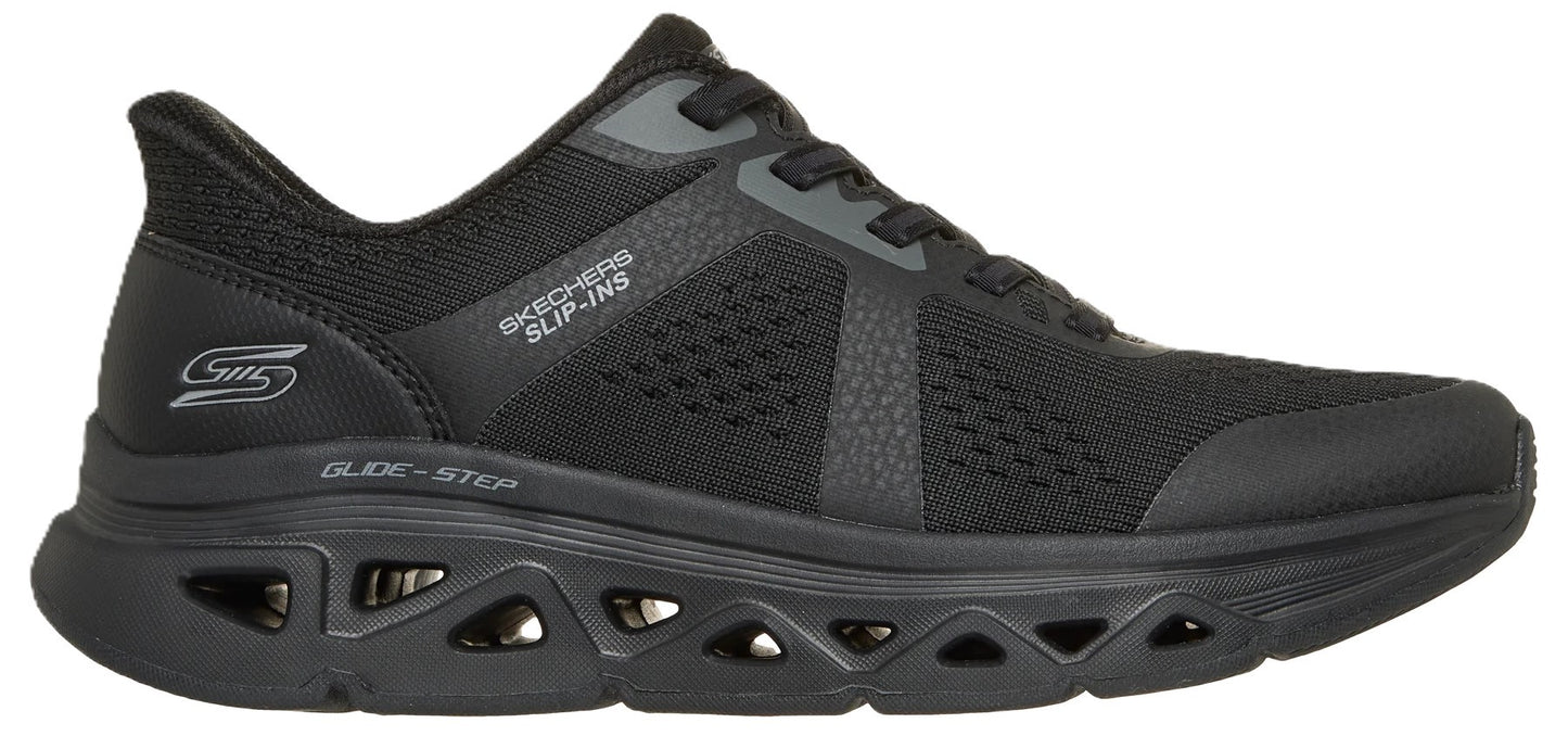 A black Skechers Slip-ins Glide-Step athletic shoe, viewed from the side, featuring a mesh upper, black laces, a geometric cutout sole design, and the text Skechers Slip-ins and Glide-Step branded on the exterior.