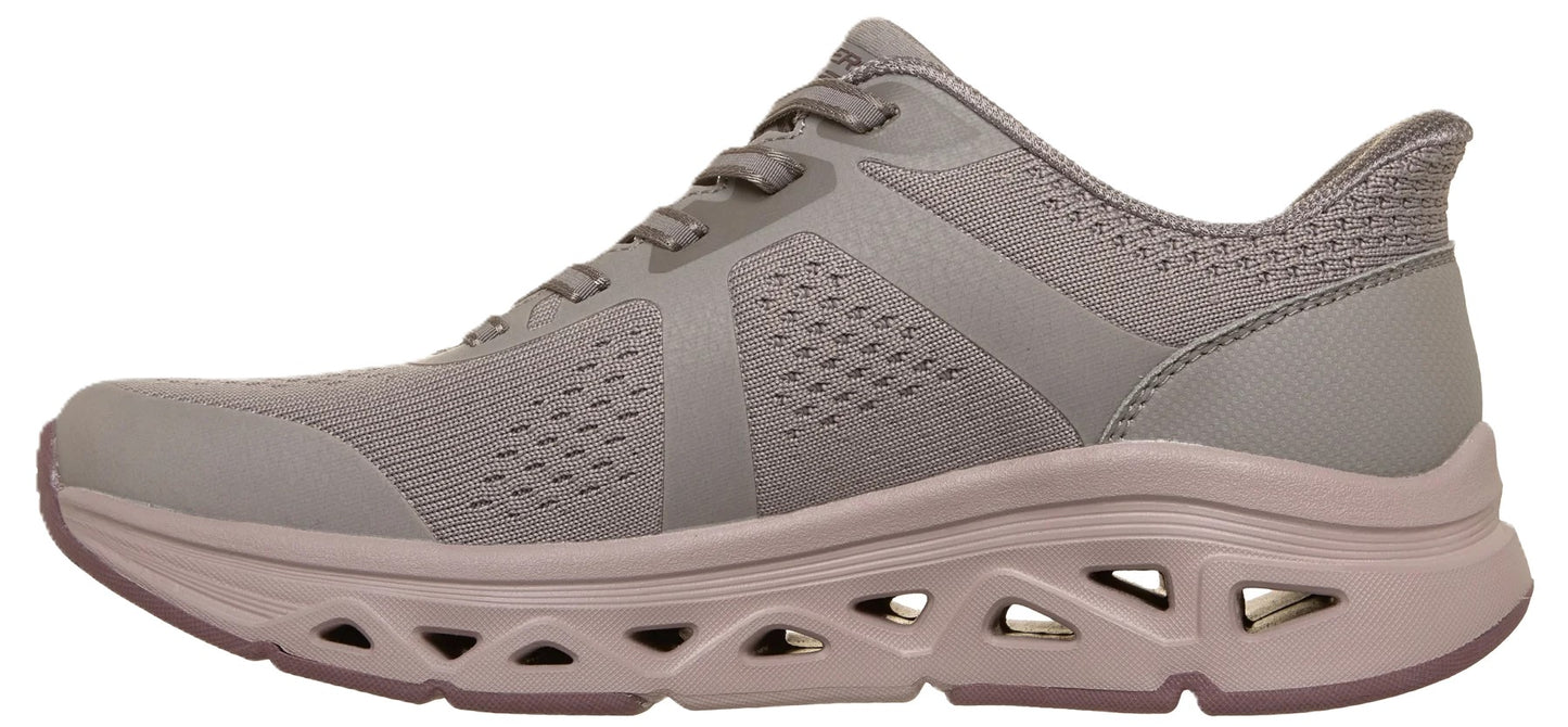 A light gray women's athletic sneaker with a breathable knit upper, laces, and a thick, chunky midsole featuring distinctive triangular cutouts along the side profile.