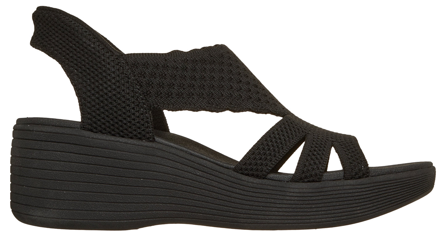 Black knitted sandal with a wedge heel and slingback strap.