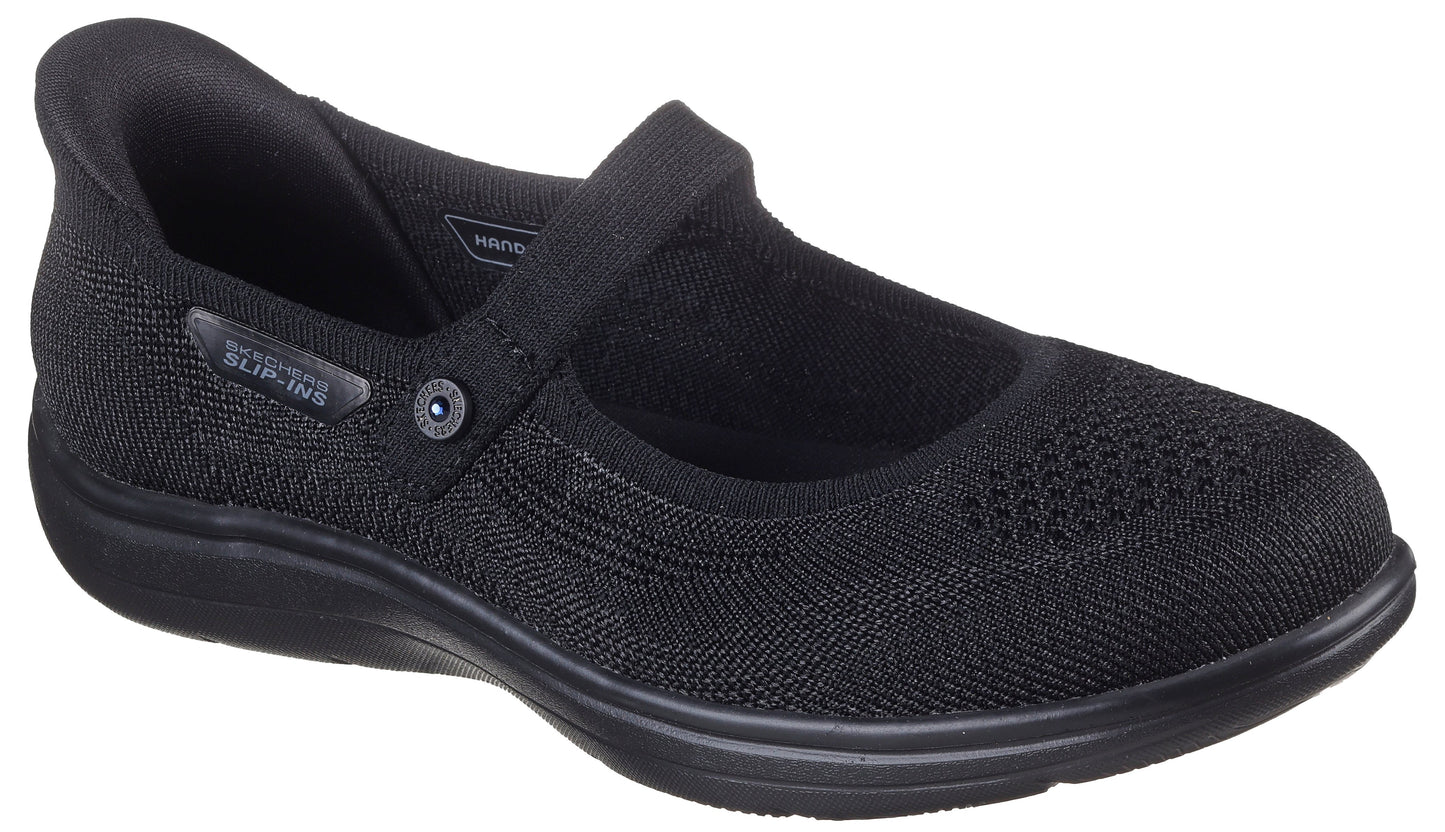 Black slip-on Mary Jane style shoe with a flexible upper and a strap with a button.