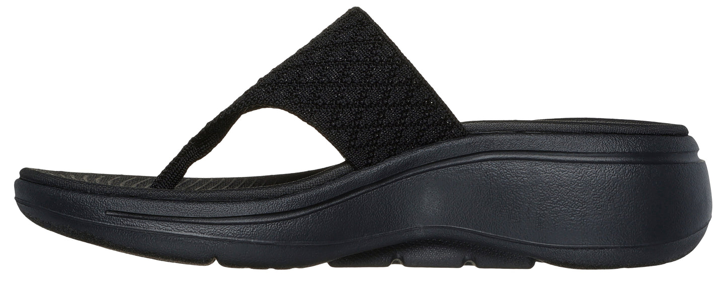 Black thong sandal with a knit strap and a wedge heel.