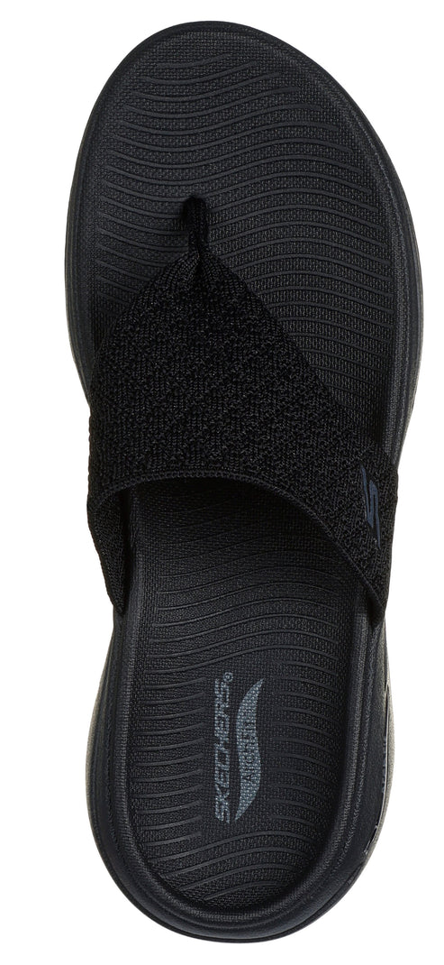 A black sandal with a toe post and an asymmetrical upper strap.