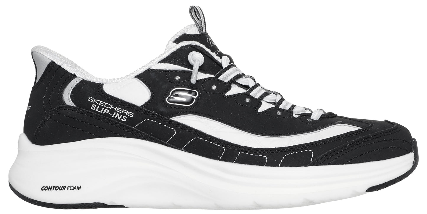 A black and white athletic shoe featuring a thick white Contour Foam sole, black mesh and synthetic upper, white accent stripes, white laces, and 'Skechers Slip-ins' text printed on the side.