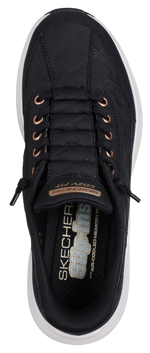 Black sneakers with rose gold eyelets and white soles.