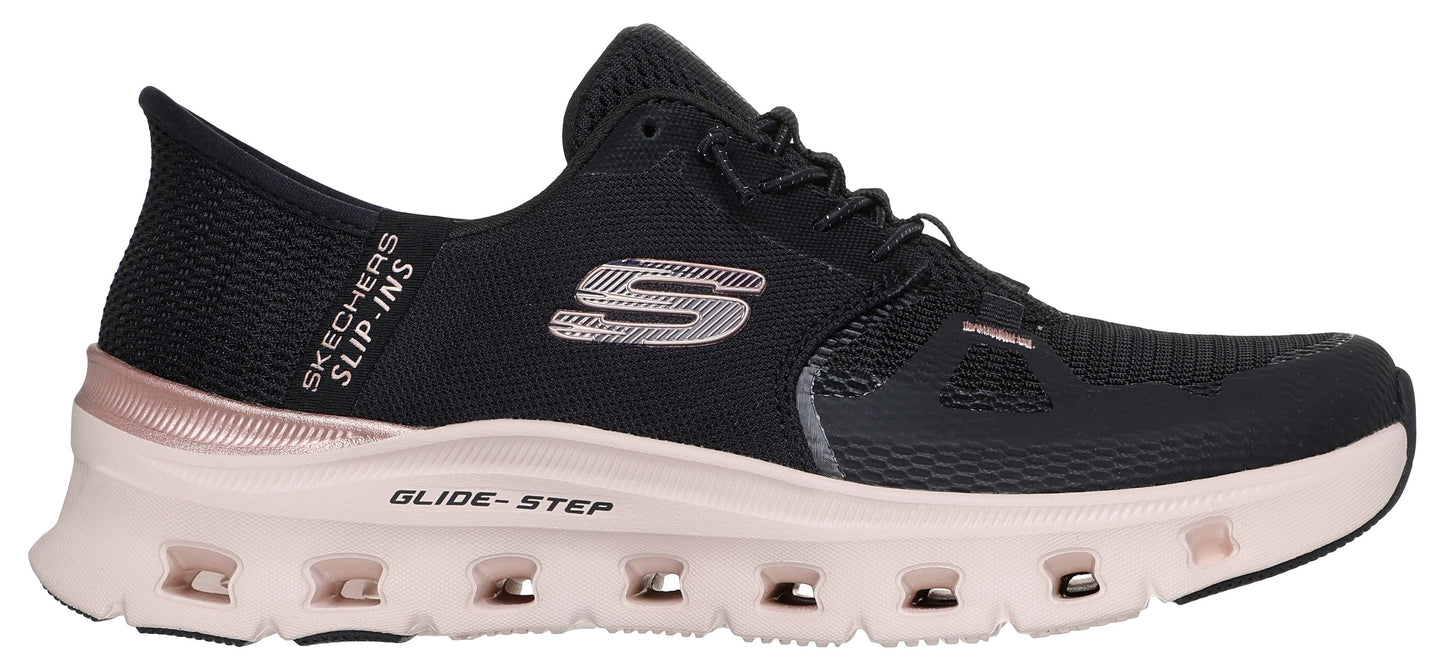 A black athletic shoe with a light pink sole and a silver "S" logo on the side.
