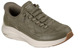 An olive green, quilted-fabric sneaker with a thick, white, textured midsole, lace-up front, and a tan rubber outsole, featuring 'SKECHERS COZY FIT' branding on the tongue and 'CONTOUR FOAM' text on the heel.