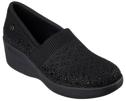Black slip-on wedge shoe with knit upper and gem embellishments.
