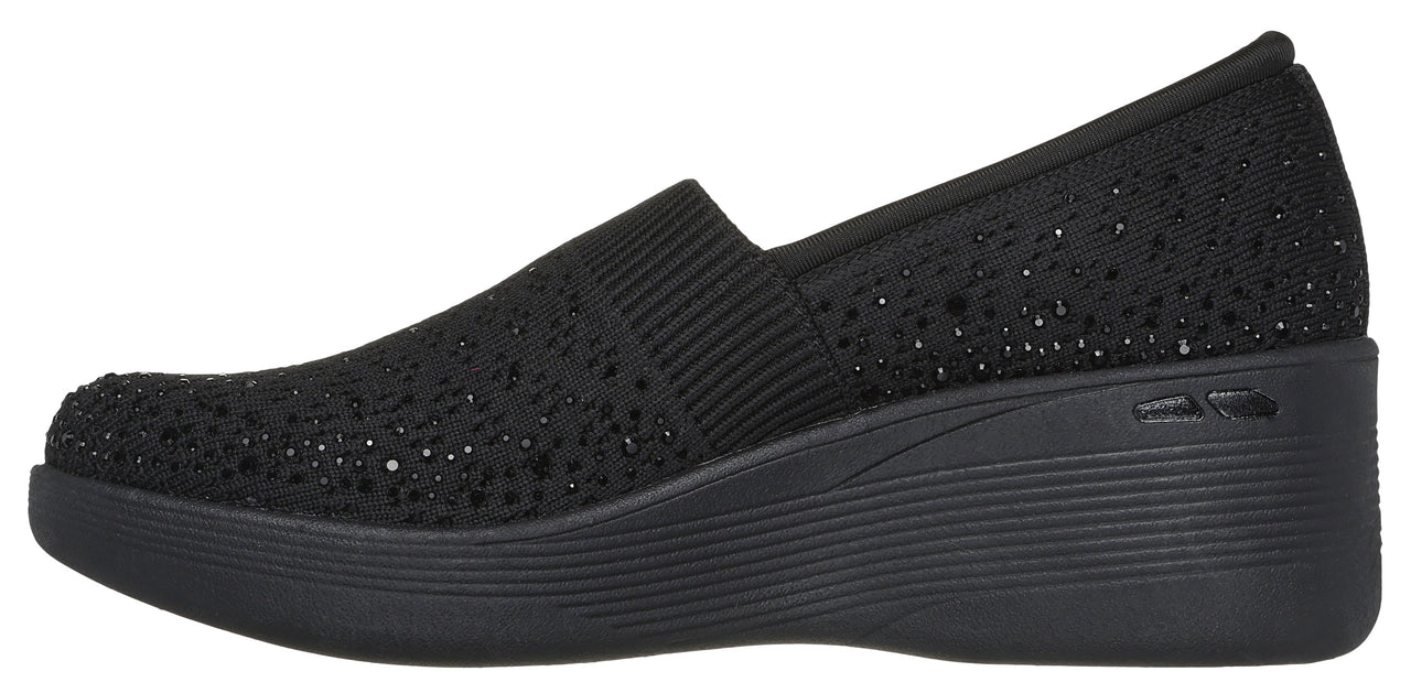 Black slip-on shoe with a wedge heel.