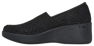 Black slip-on shoe with a wedge heel.