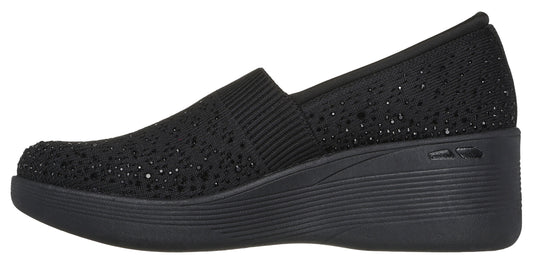 Black slip-on shoe with a wedge heel.