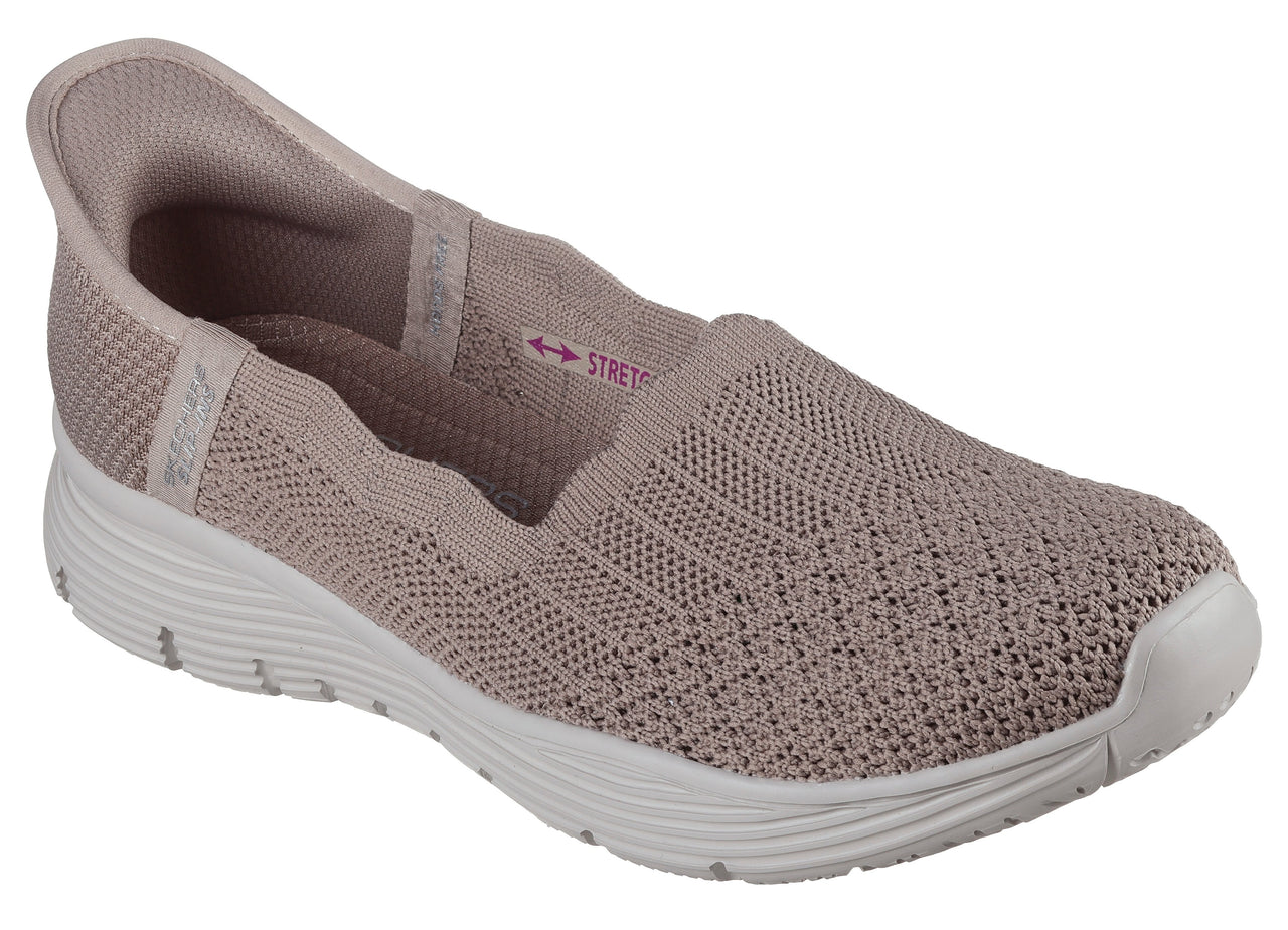 Slip-on light pink athletic shoe with stretchy knit upper and white soles.