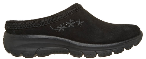 A black suede mule with a textured woven collar and embroidered flower detail on the side, featuring a thick, black rubber treaded sole.