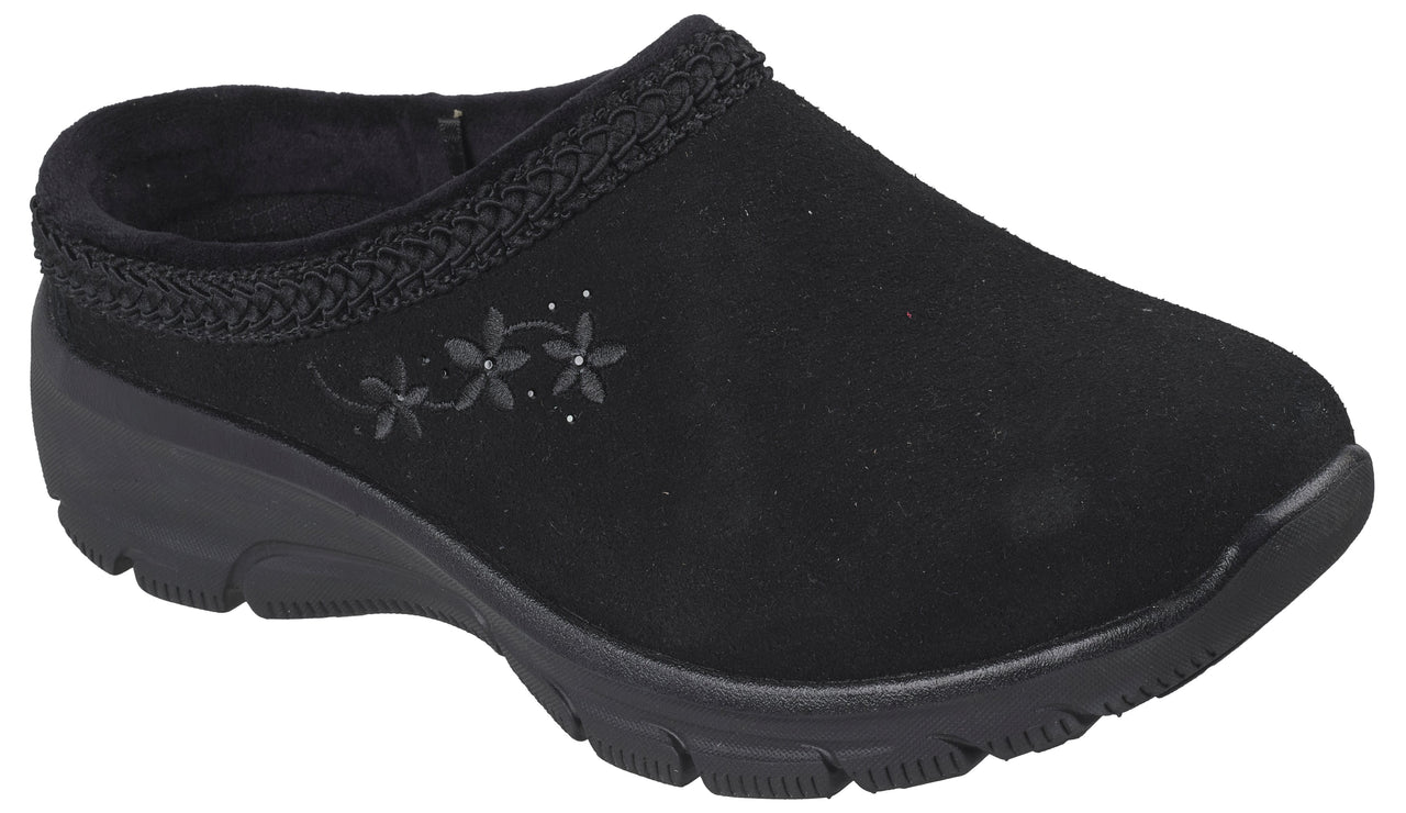 A black slip-on mule shoe made of a suede-like material, featuring a braided trim along the collar and an embroidered design of three small flowers with tiny dots on the outer side, set on a thick black molded rubber sole.