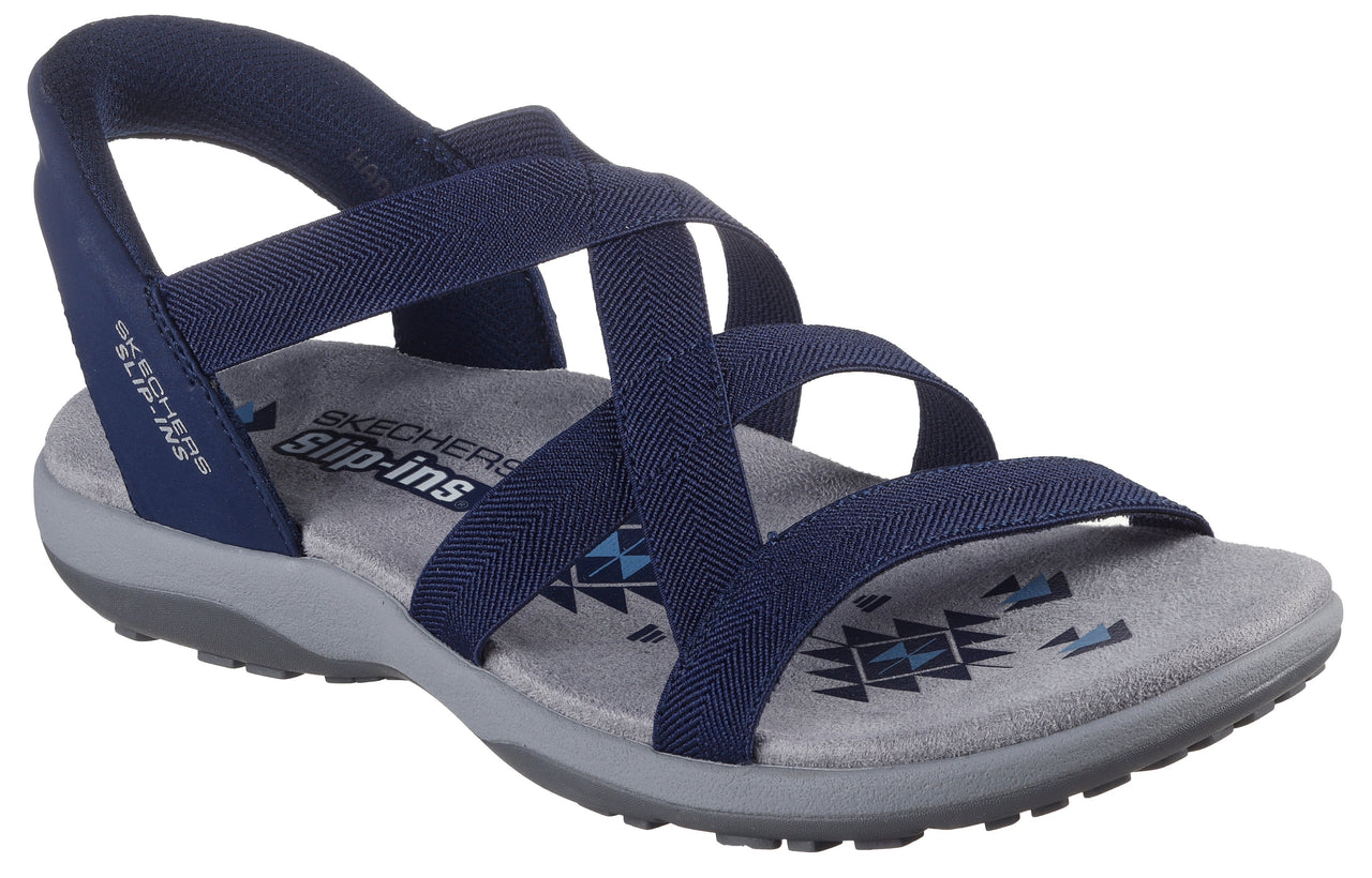 Navy blue sandal featuring elastic cross straps, a gray sole, and the words 'SLIP-INS' printed on the heel.