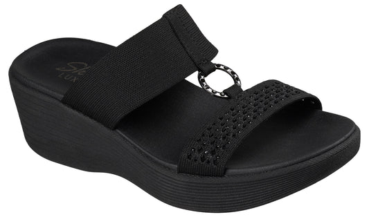 Black wedge sandal with two elastic straps and decorative ring.