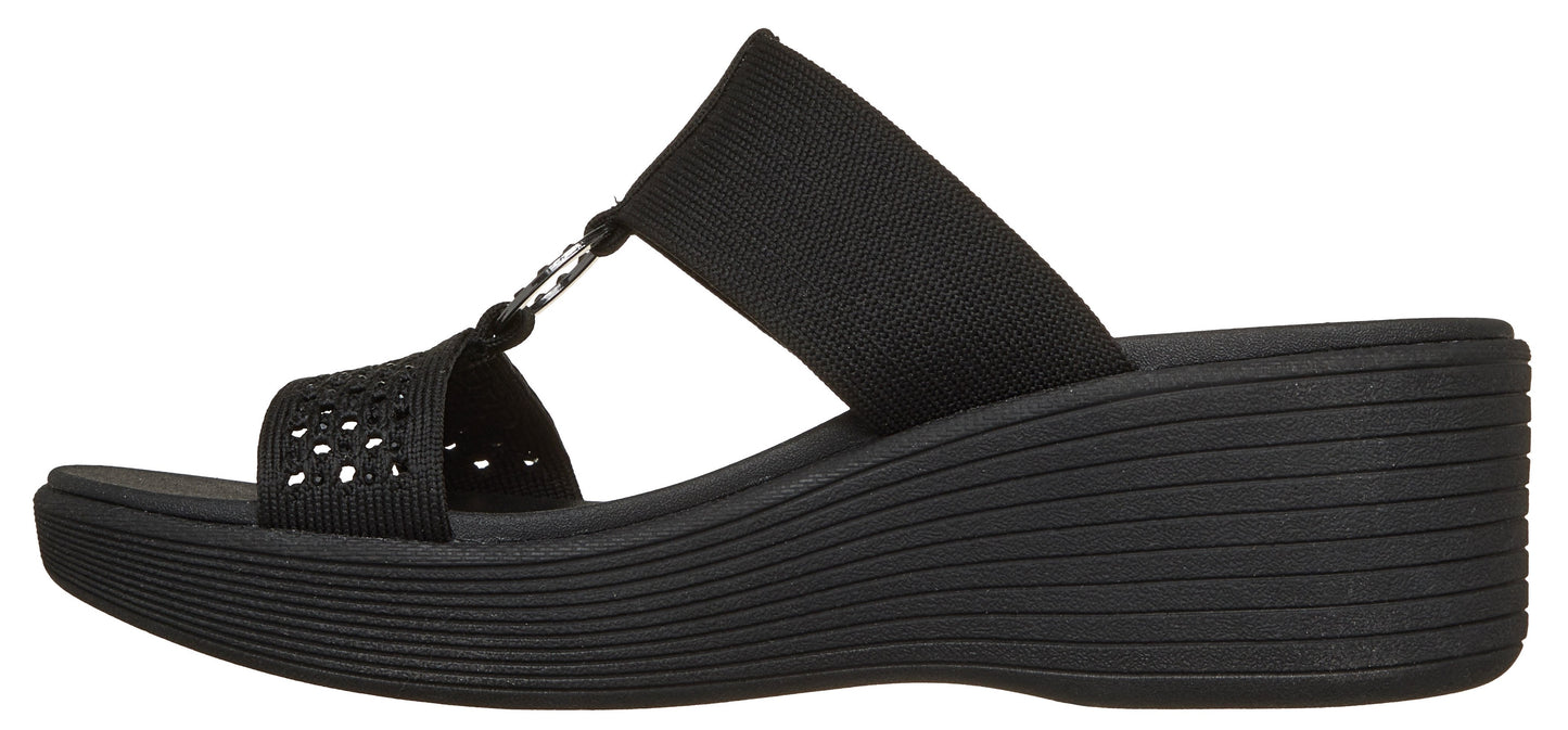 A black slide-on sandal with a wedge heel.