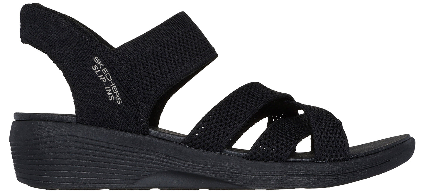 Black sandal with criss-cross straps and "SKECHERS SLIP-INS" text on the heel strap.