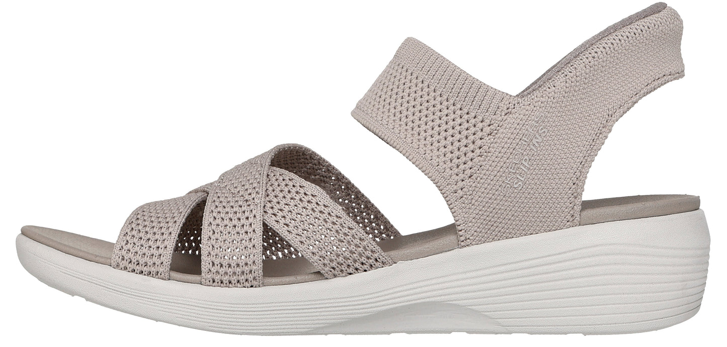 A sandal with crisscrossing beige straps and a white sole.