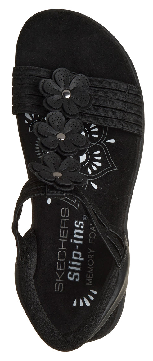Black sandal with floral details and text "SKECHERS Slip-ins MEMORY FOAM" on the sole.