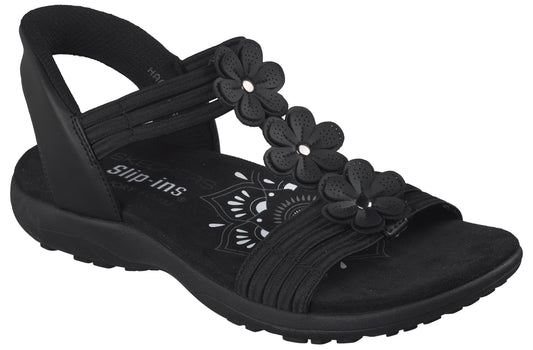Black sandal featuring flower accents, elastic straps, and a low profile sole.