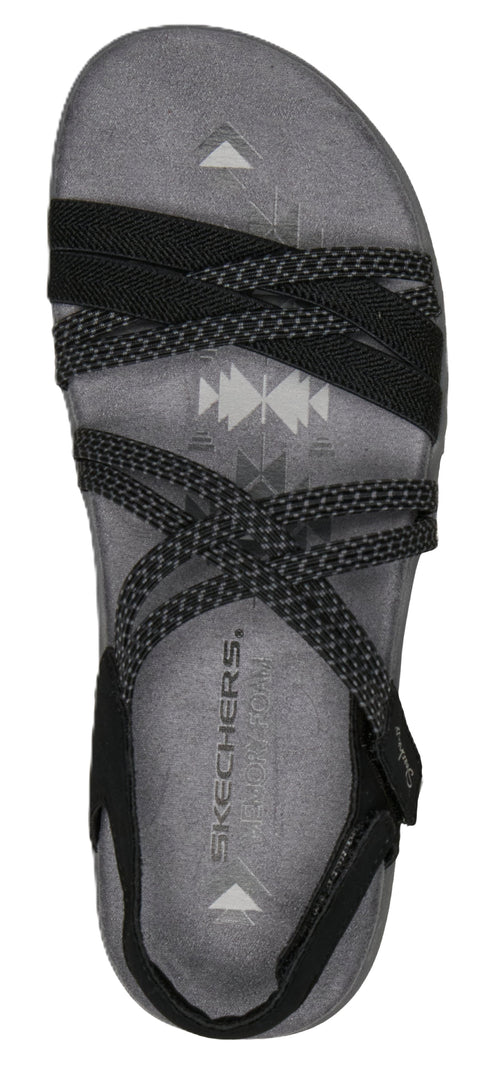A top-down view of a sandal with multiple black crisscrossing straps on a gray textured insole.
