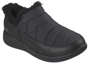 A black, slip-on winter ankle boot featuring a quilted, padded upper, a plush faux-fur collar, and a thick, solid-colored rubber sole.